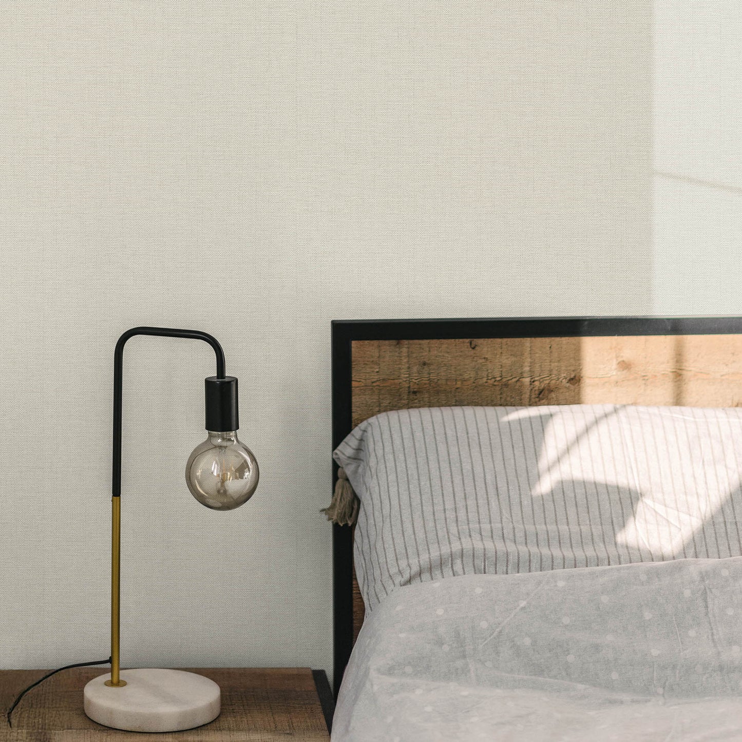 Sepia-toned wallpaper with a woven jute texture and an abstract traditional pattern.