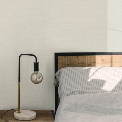 Sepia-toned wallpaper with a woven jute texture and an abstract traditional pattern.