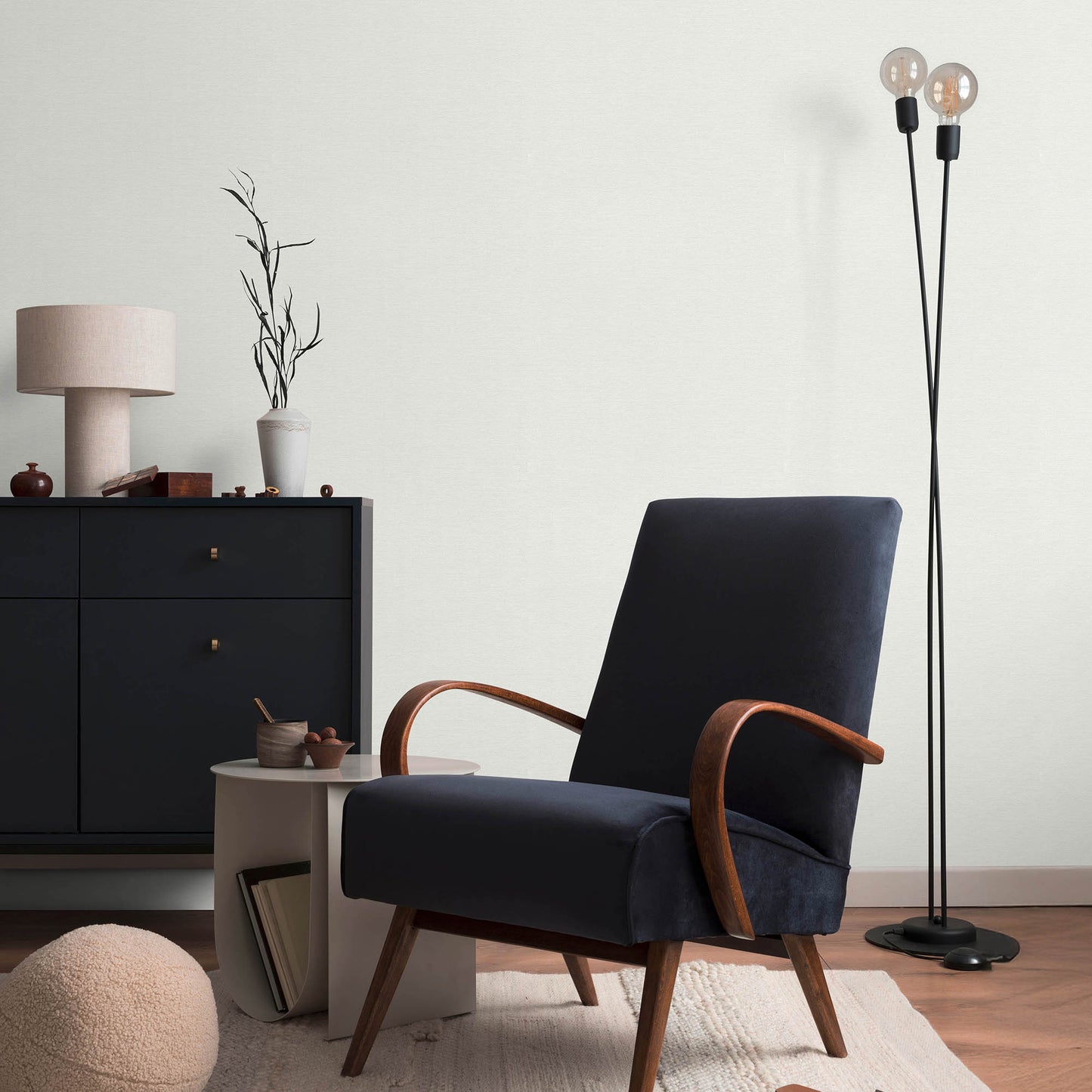 Navy blue upholstered lounge chair with curved walnut arms and legs in a modern mid-century living room setting.