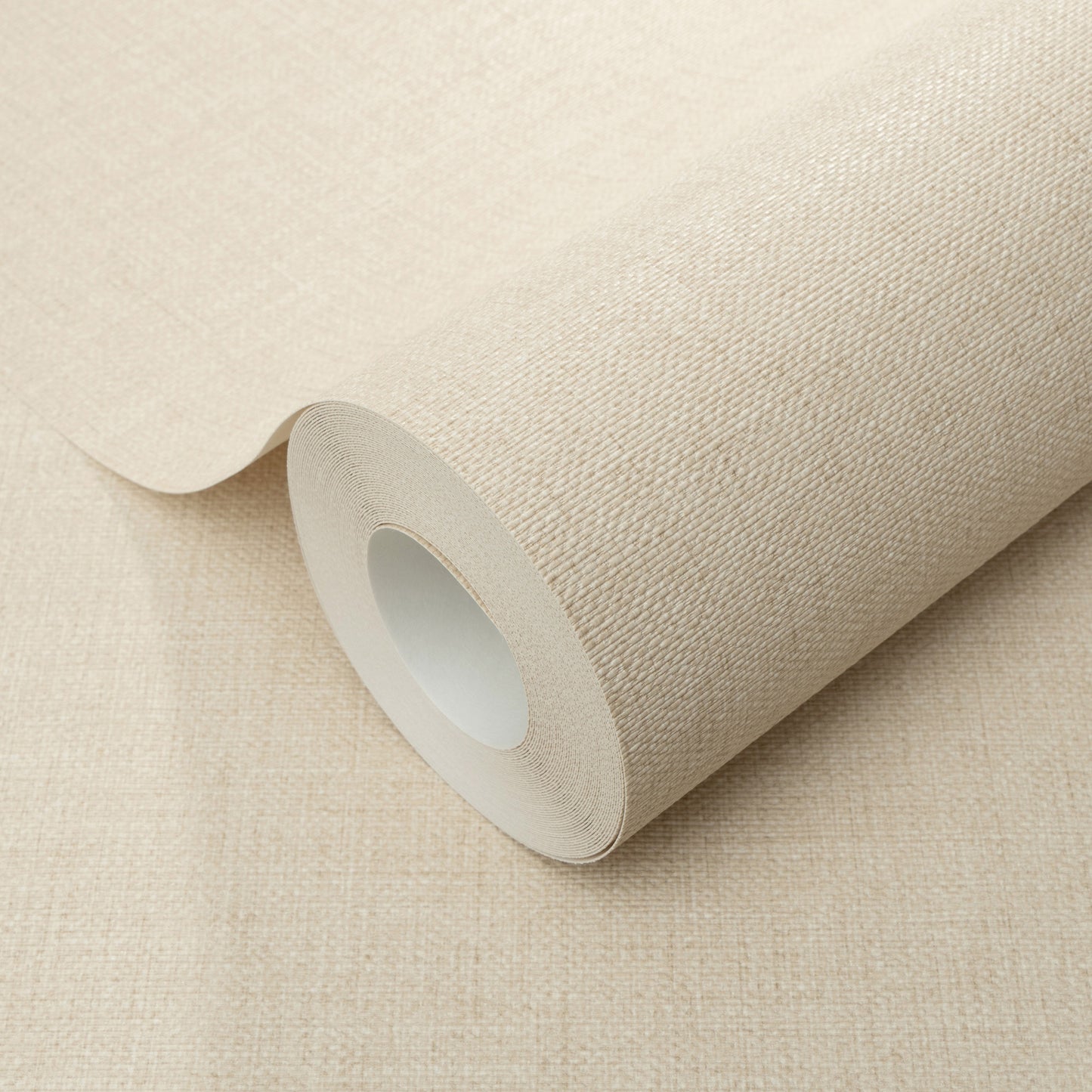Beige wallpaper roll with a woven canvas-like texture, rolled around a white core.