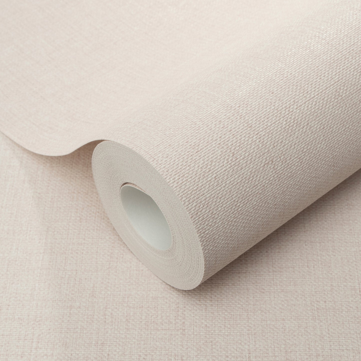 Pink jute-texture wallpaper roll with a cardboard core, partially unrolled.