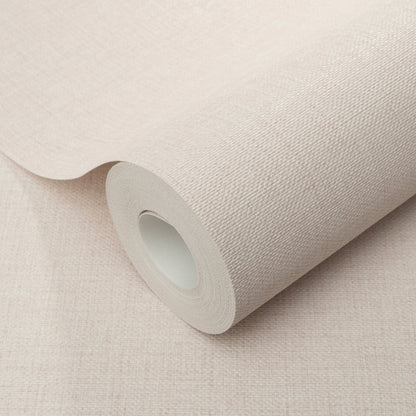 Pink jute-texture wallpaper roll with a cardboard core, partially unrolled.