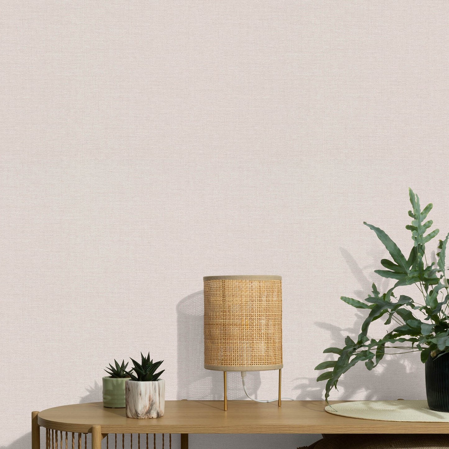 Pink wallpaper with a subtle jute texture and an abstract traditional pattern.