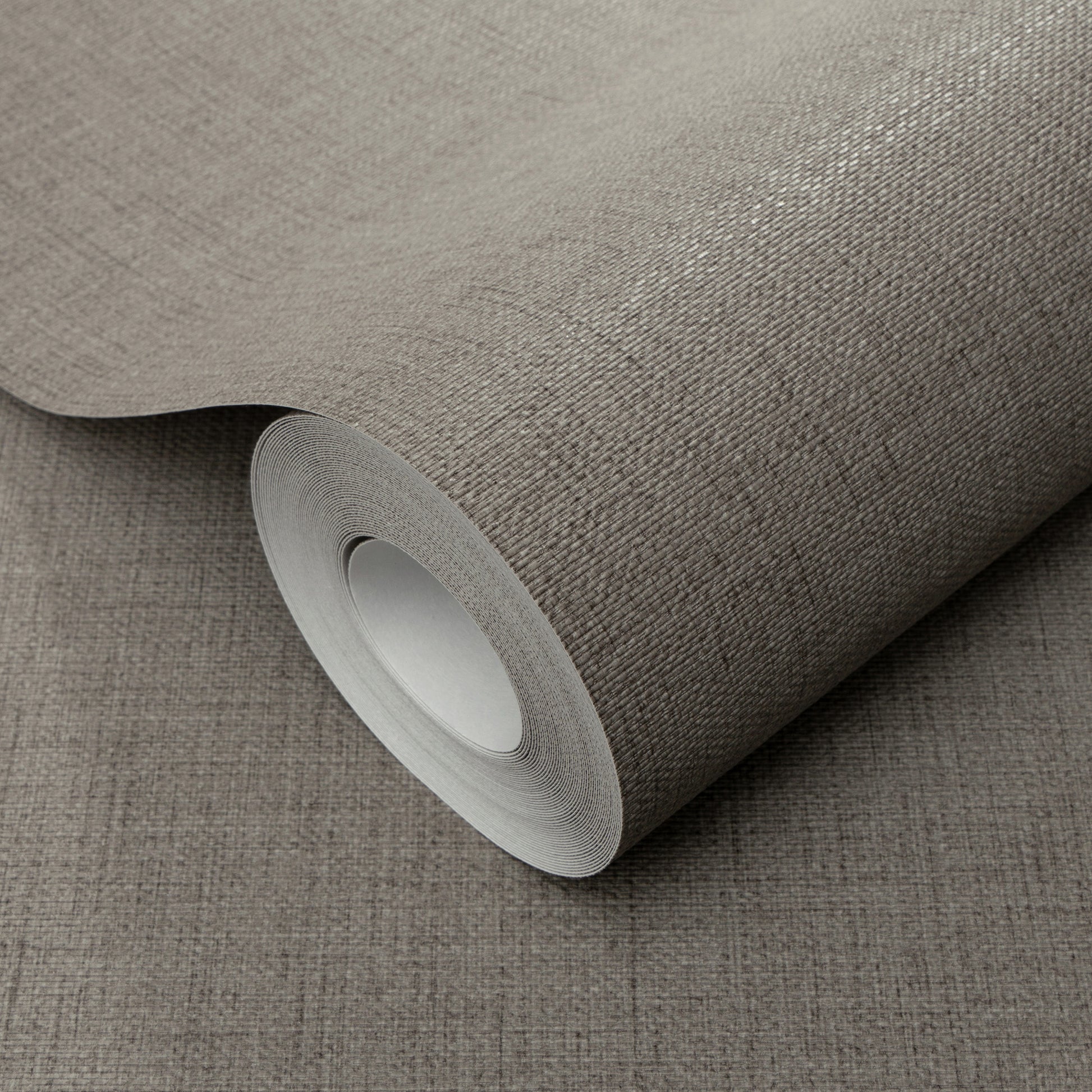 Rolled taupe-gray textured wallpaper with a woven linen pattern and fabric-like finish.