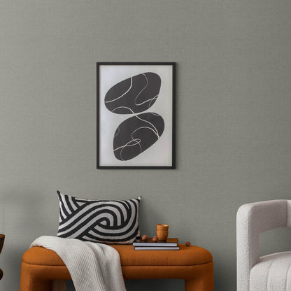 Living room scene with orange ottoman, black-and-white zigzag pillow, white throw, and abstract framed art on a gray wall.
