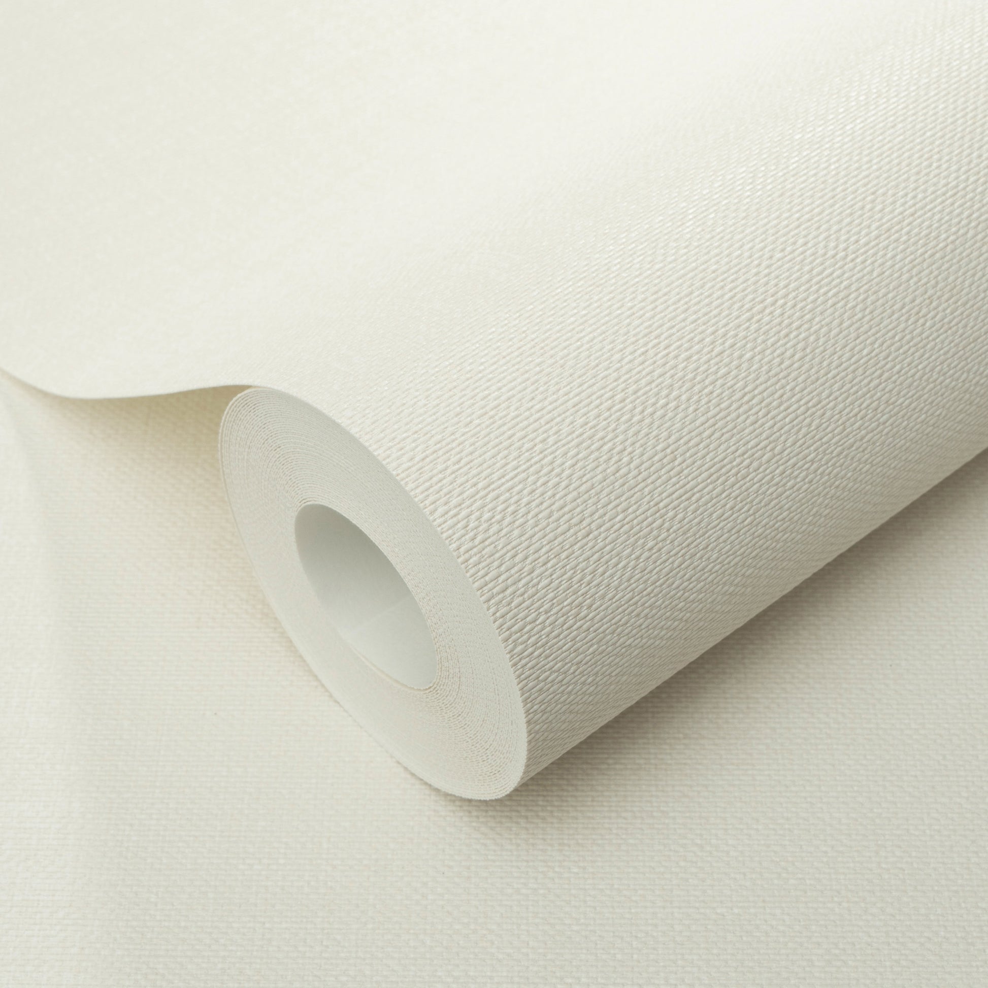 White textured wallpaper roll with visible weave and jute texture, off-white, partially unrolled.