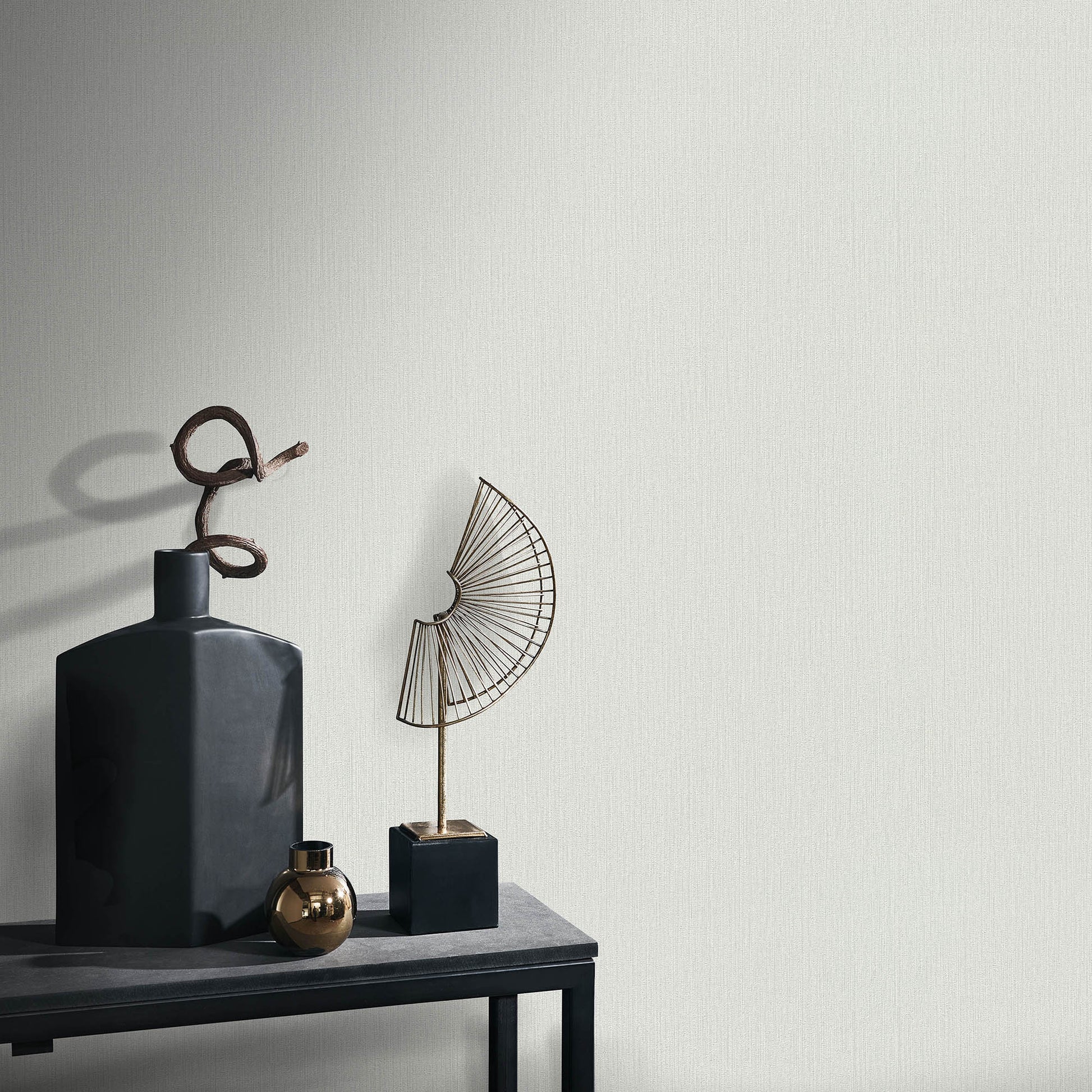 Gray wallpaper with a soft loom stria texture and an abstract traditional pattern.
