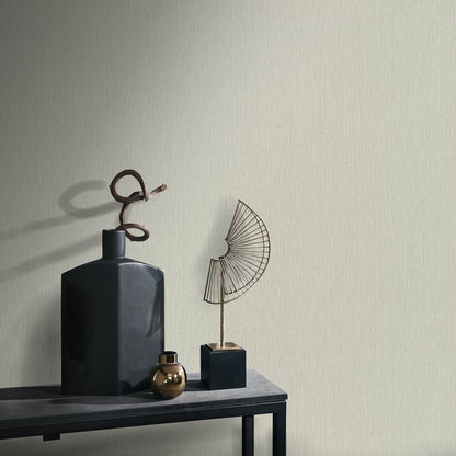 Matte blue geometric vase with a spiraled metal accent, small gold orb, and wire fan sculpture on a dark console table.
