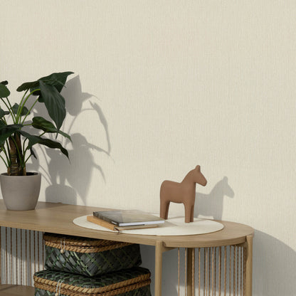 Wooden console table with a potted plant, beige horse figurine, round mat, a book, and woven baskets below.