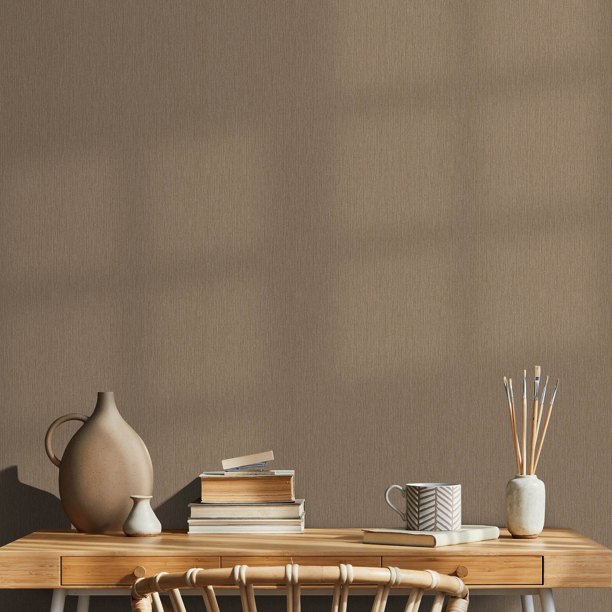 Wooden console table with beige ceramic vase, small white vase, books, mug, and reed diffuser.