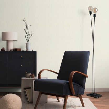 Mid-century navy fabric lounge chair with curved wooden arms and tapered legs in a chic living room.