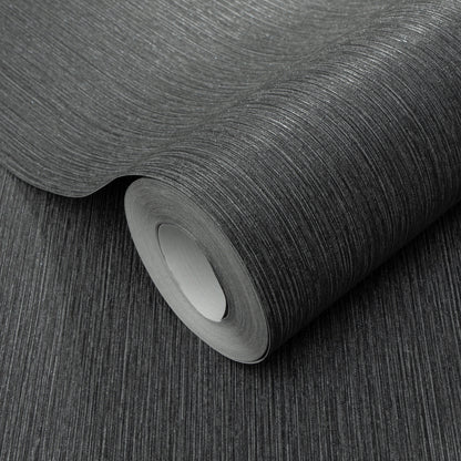 Charcoal textured wallpaper roll with subtle vertical linear grain, matte finish, partially unrolled for home decor.