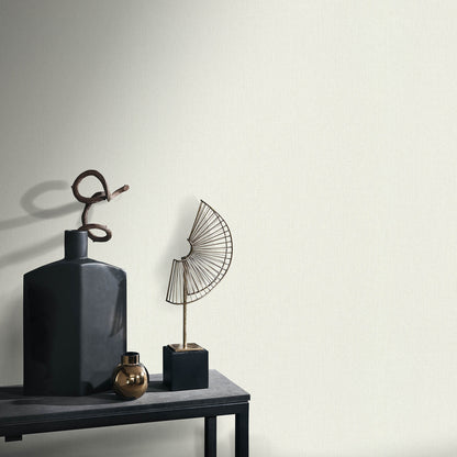Dark matte ceramic bottle vase with looped twig, bronze orb, and geometric wire fan sculpture on a black pedestal table.