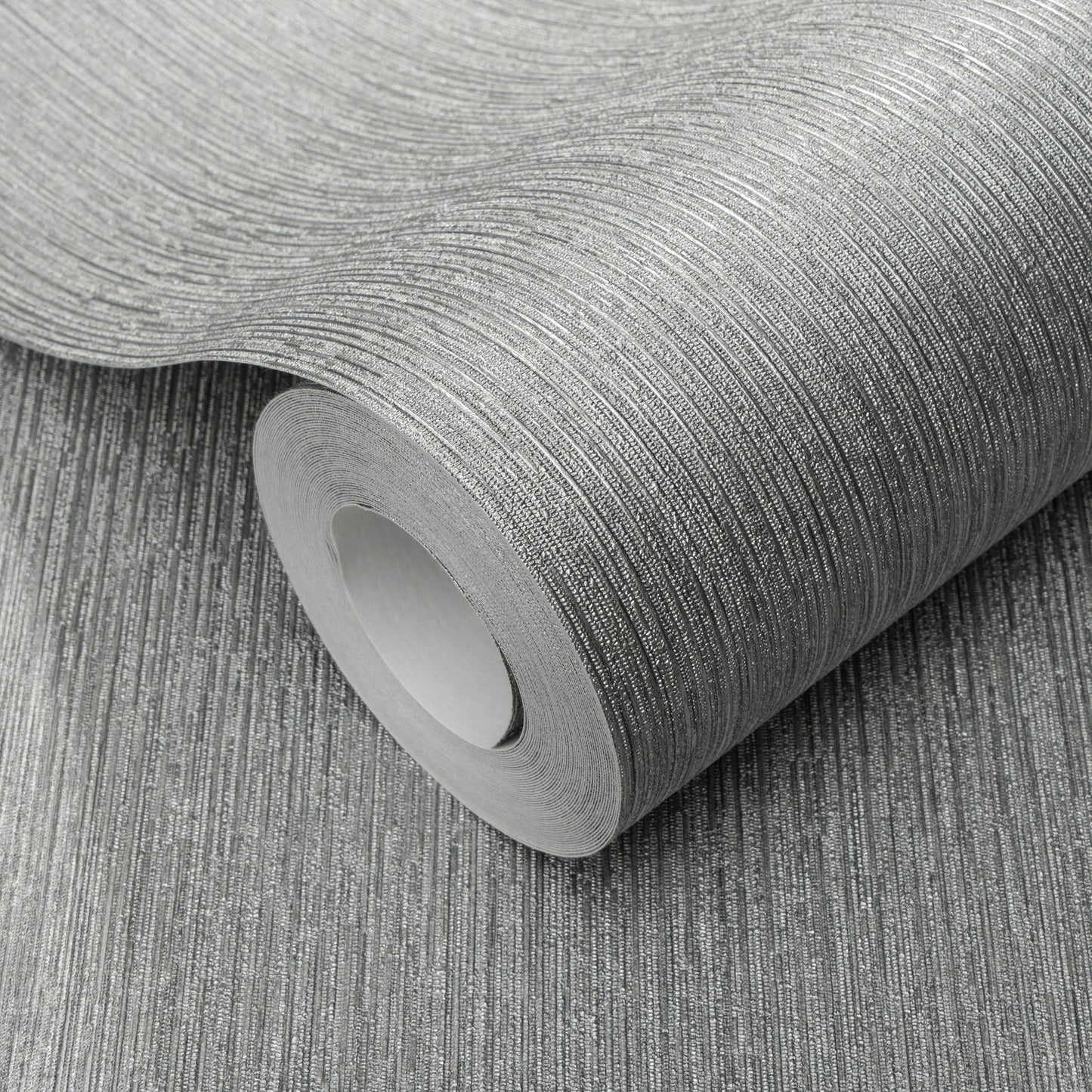 Roll of silver textured wallpaper with fine linear pattern and metallic sheen.