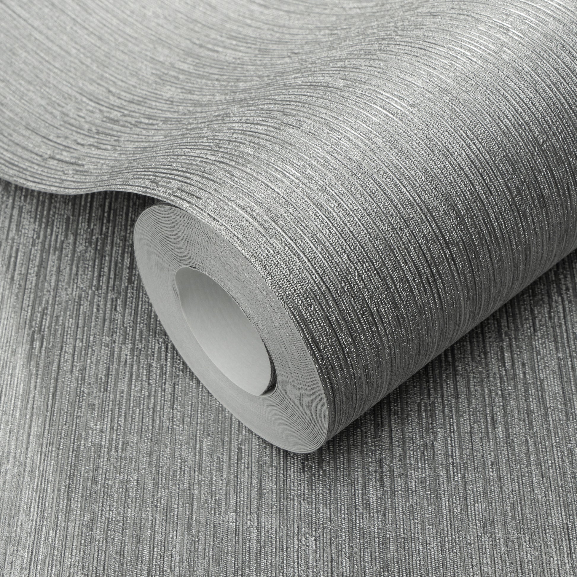 Roll of silver textured wallpaper with fine linear pattern and metallic sheen.