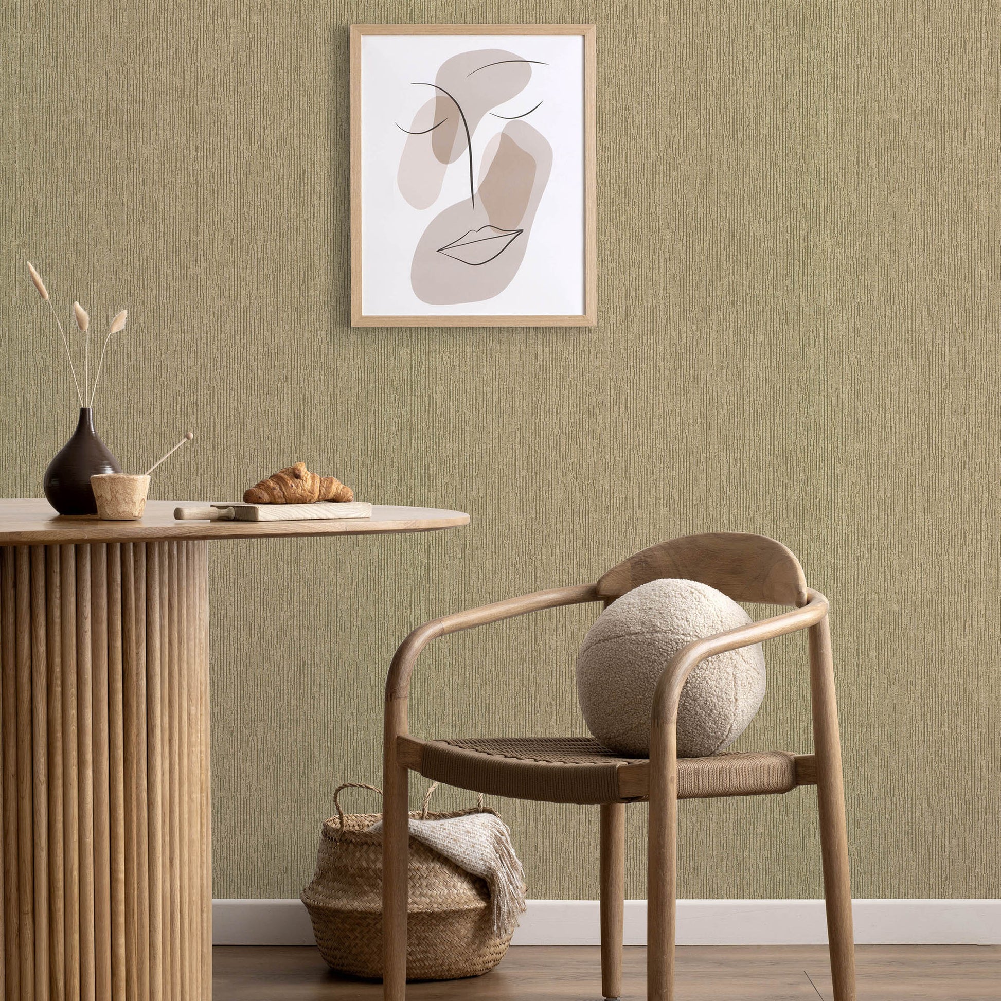 Natural wood round table with vertical-slat base, woven chair, wool ball, gold wallpaper with an abstract line art pattern.