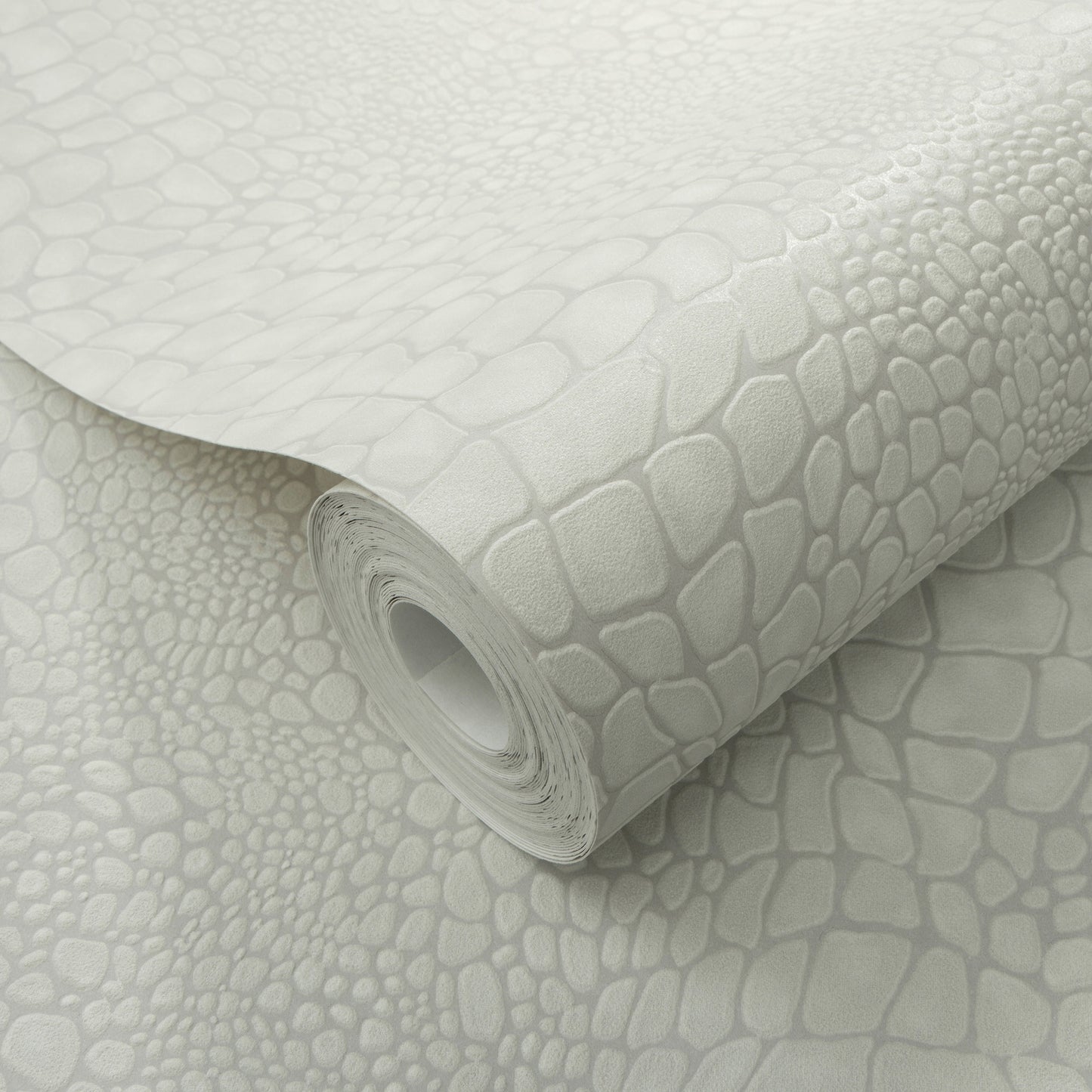 Light gray faux crocodile-skin wallpaper roll with embossed scale pattern, curled edge, decorative wall covering.