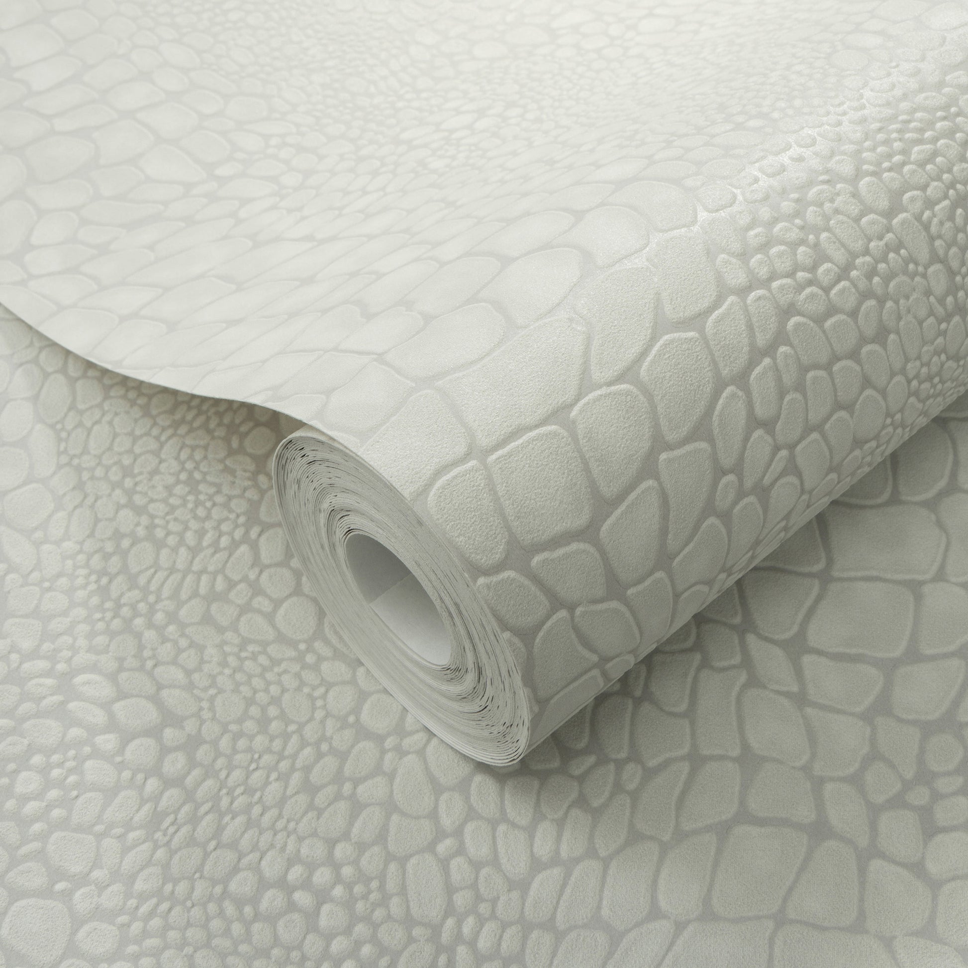 Light gray faux crocodile-skin wallpaper roll with embossed scale pattern, curled edge, decorative wall covering.
