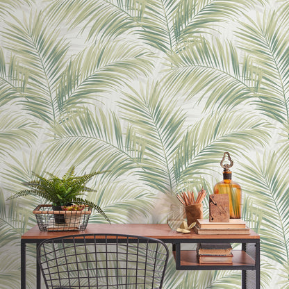 Wood desk with black metal frame and mesh shelf, fern in basket, amber bottle, books, tropical palm leaf wallpaper backdrop.