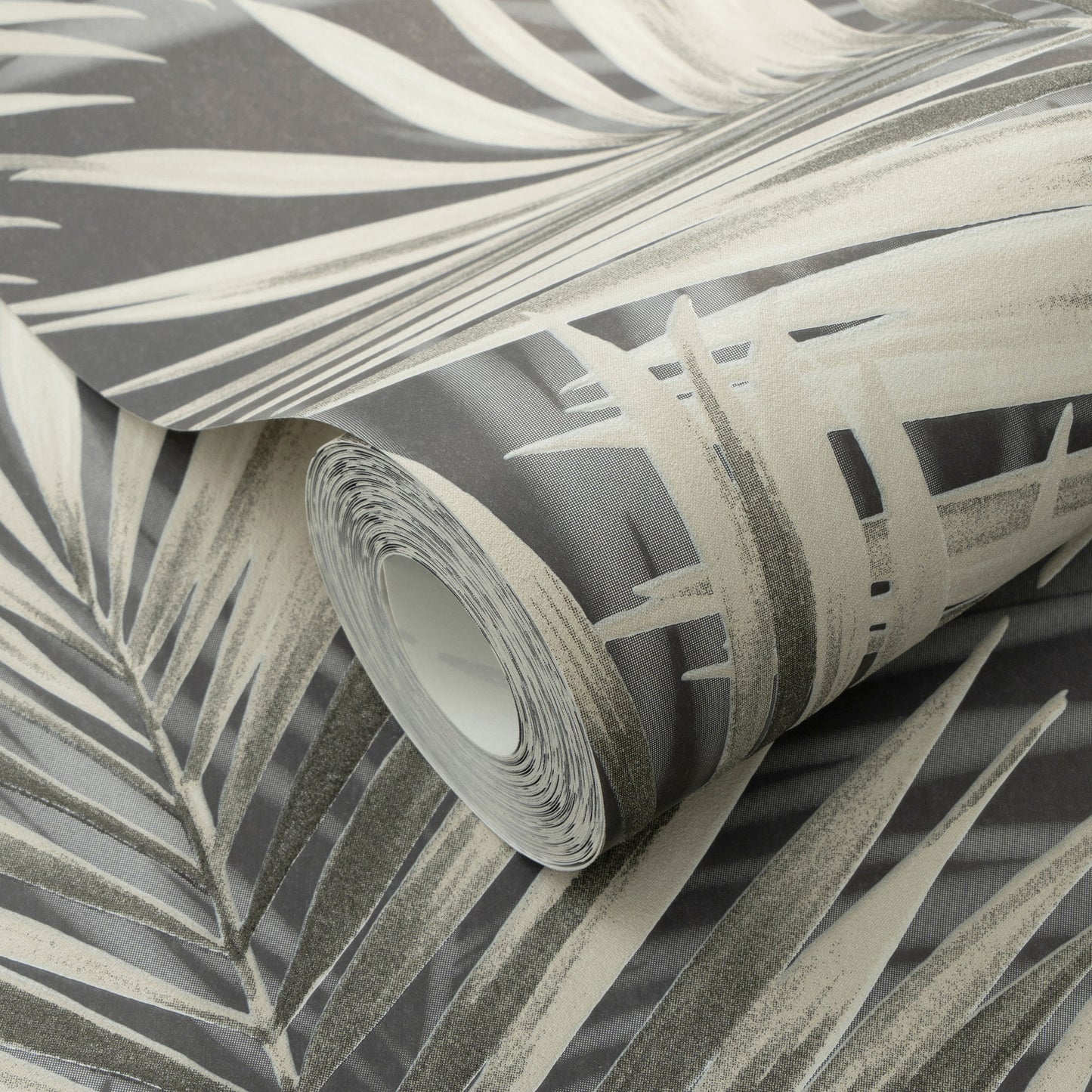 Rolled wallpaper with black palm leaves on a dark background.