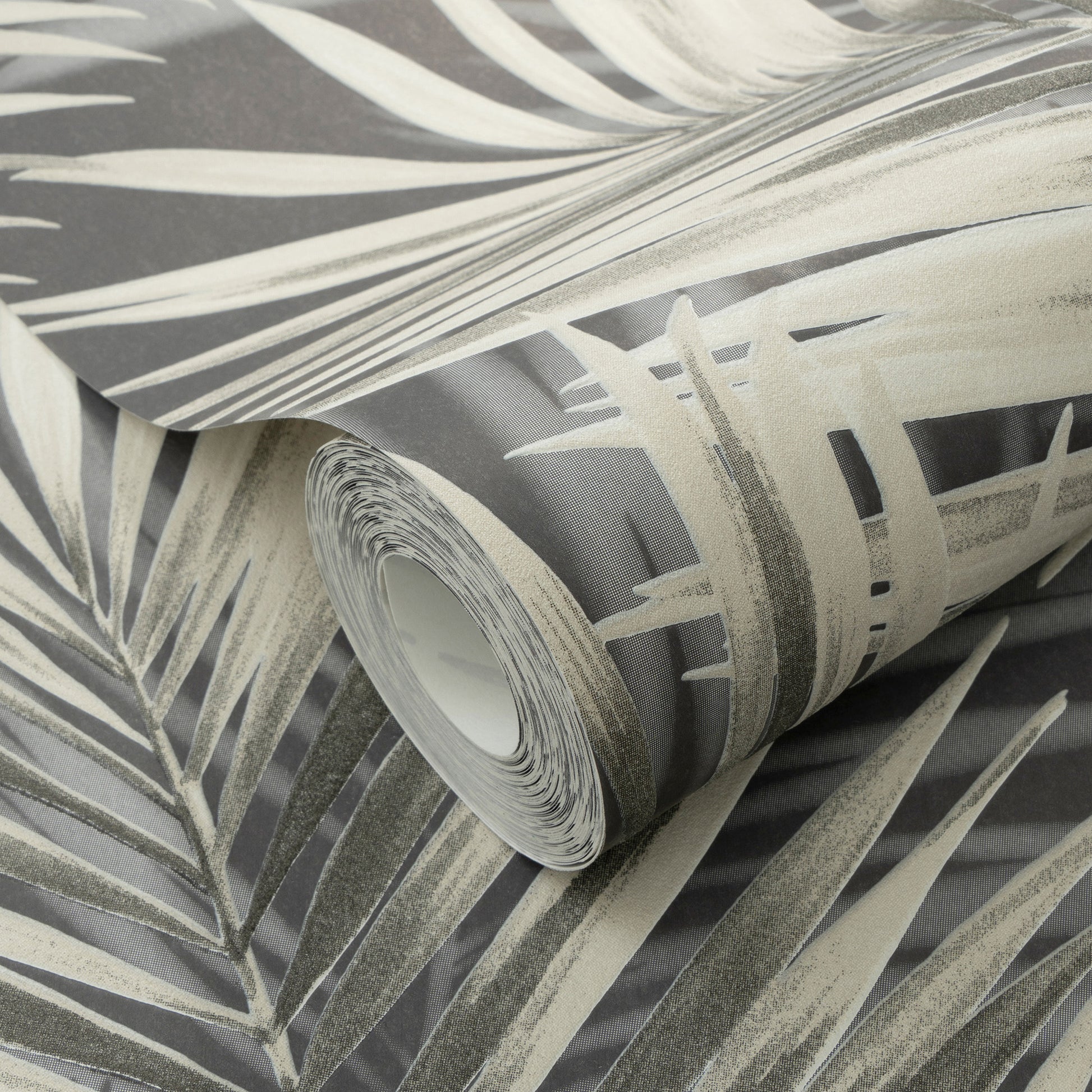 Rolled wallpaper with black palm leaves on a dark background.