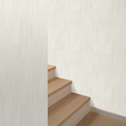 Beige wallpaper with raised stria texture on an interior wall; traditional beige pattern.