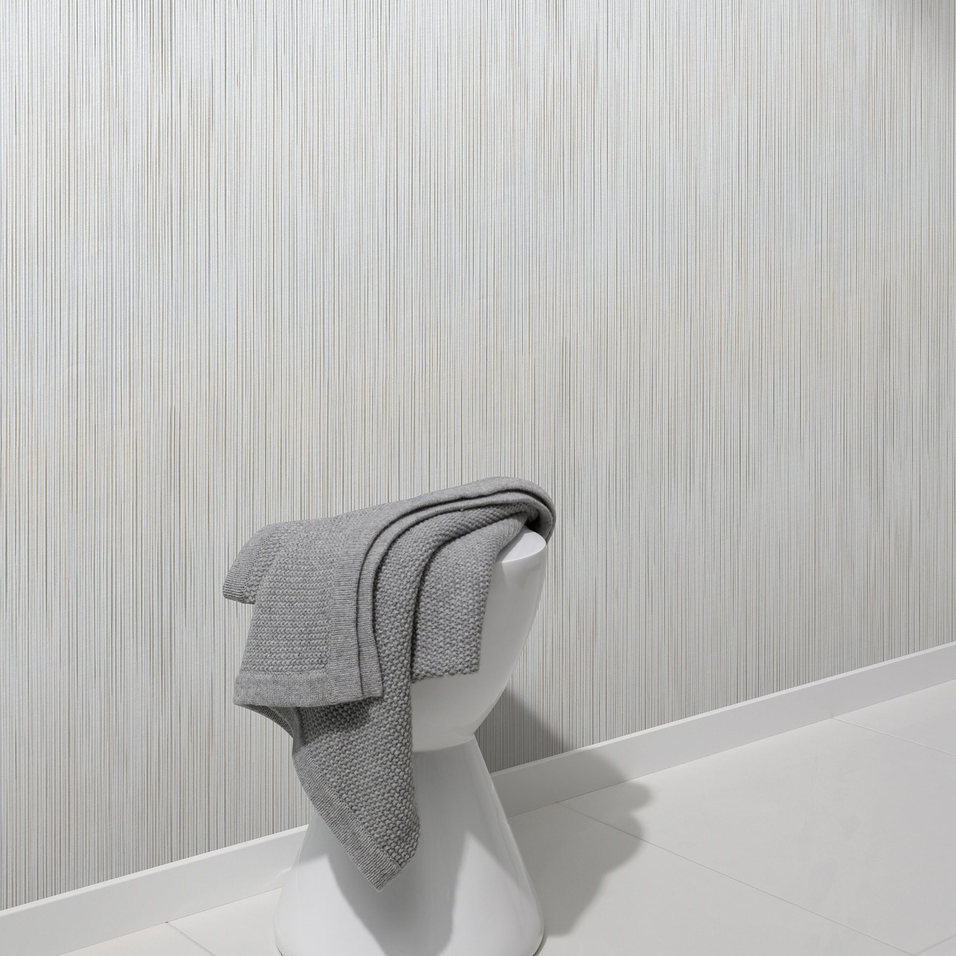 Taupe raised-stria wallpaper with a traditional pattern on a wall.