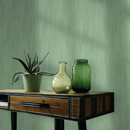 Green wallpaper with raised texture and traditional pattern.