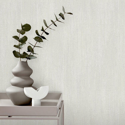 Matte gray stacked vase with eucalyptus on a pale pink tray & white curved decorative piece; minimalist modern decor.