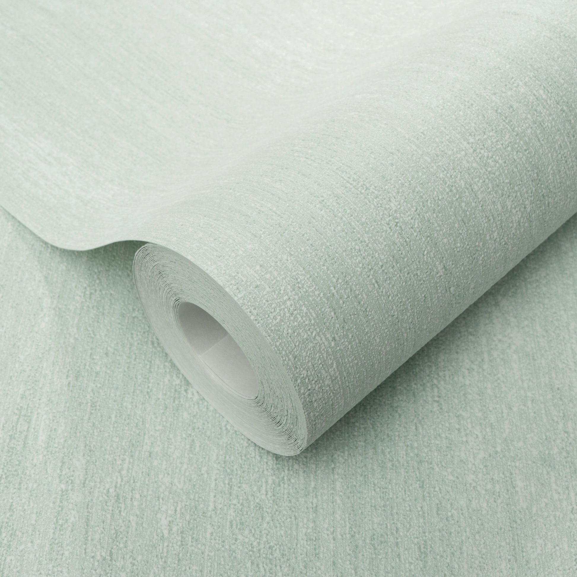 Mint green textured wallpaper roll with a subtle linen pattern, curved edge exposing the inner tube.