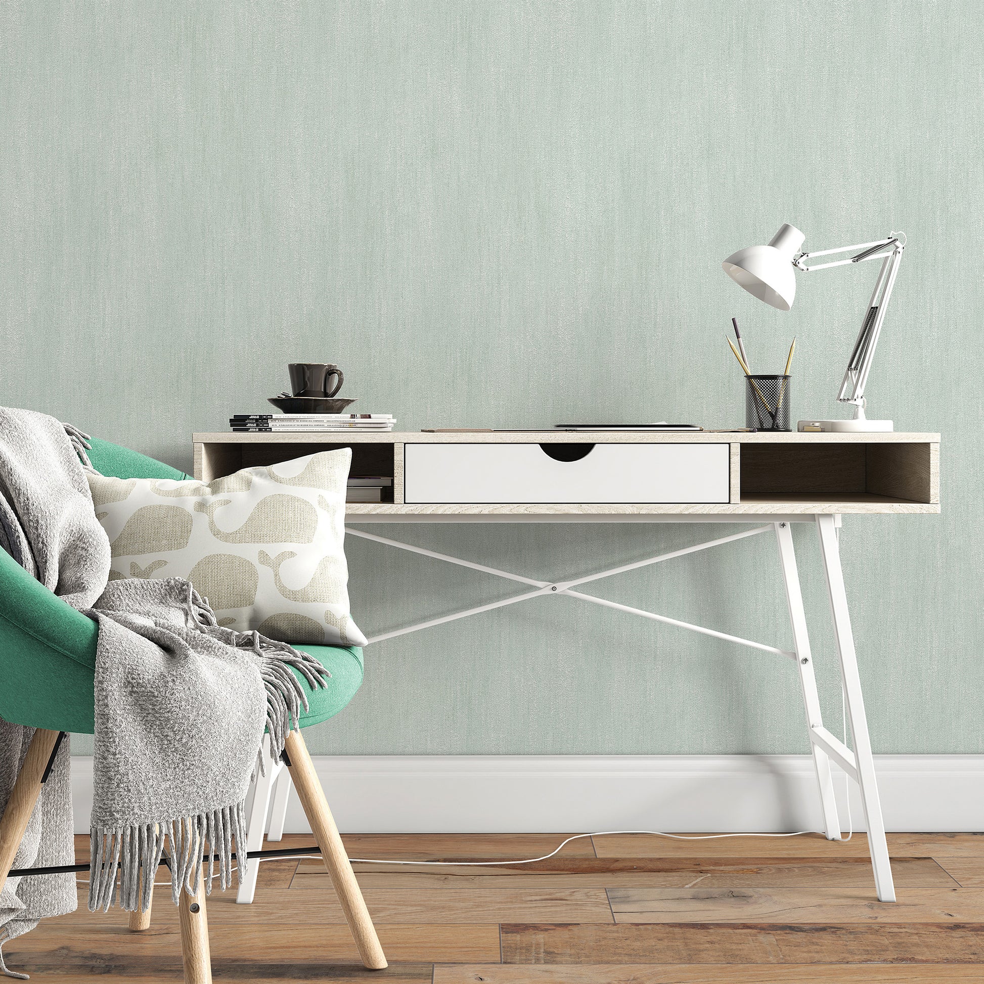 Modern desk with white drawer and wood top, metal crisscross legs, mint wall, green chair, lamp, mug, and books.