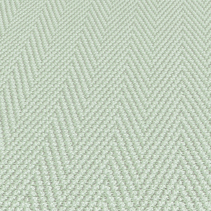 Light sage-green wallpaper with a subtle chevron stripe pattern and subtle texture.
