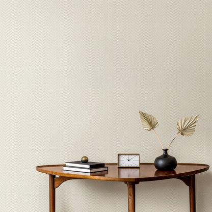Cream wallpaper with a chevron stripe pattern on a beige textured wall.