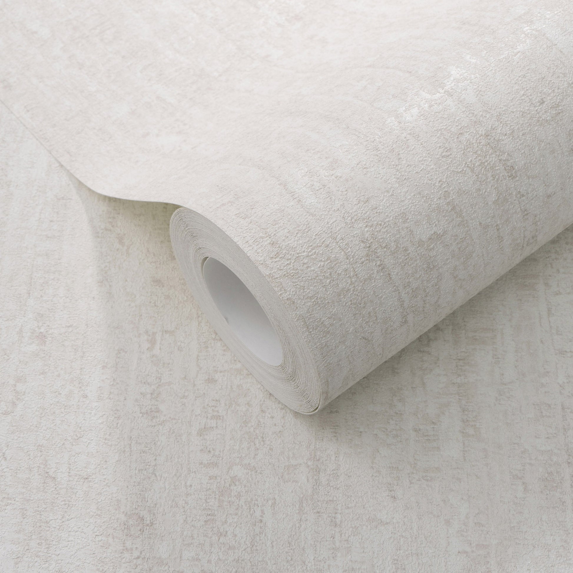 Rolled light beige textured wallpaper with a subtle stone-like pattern.
