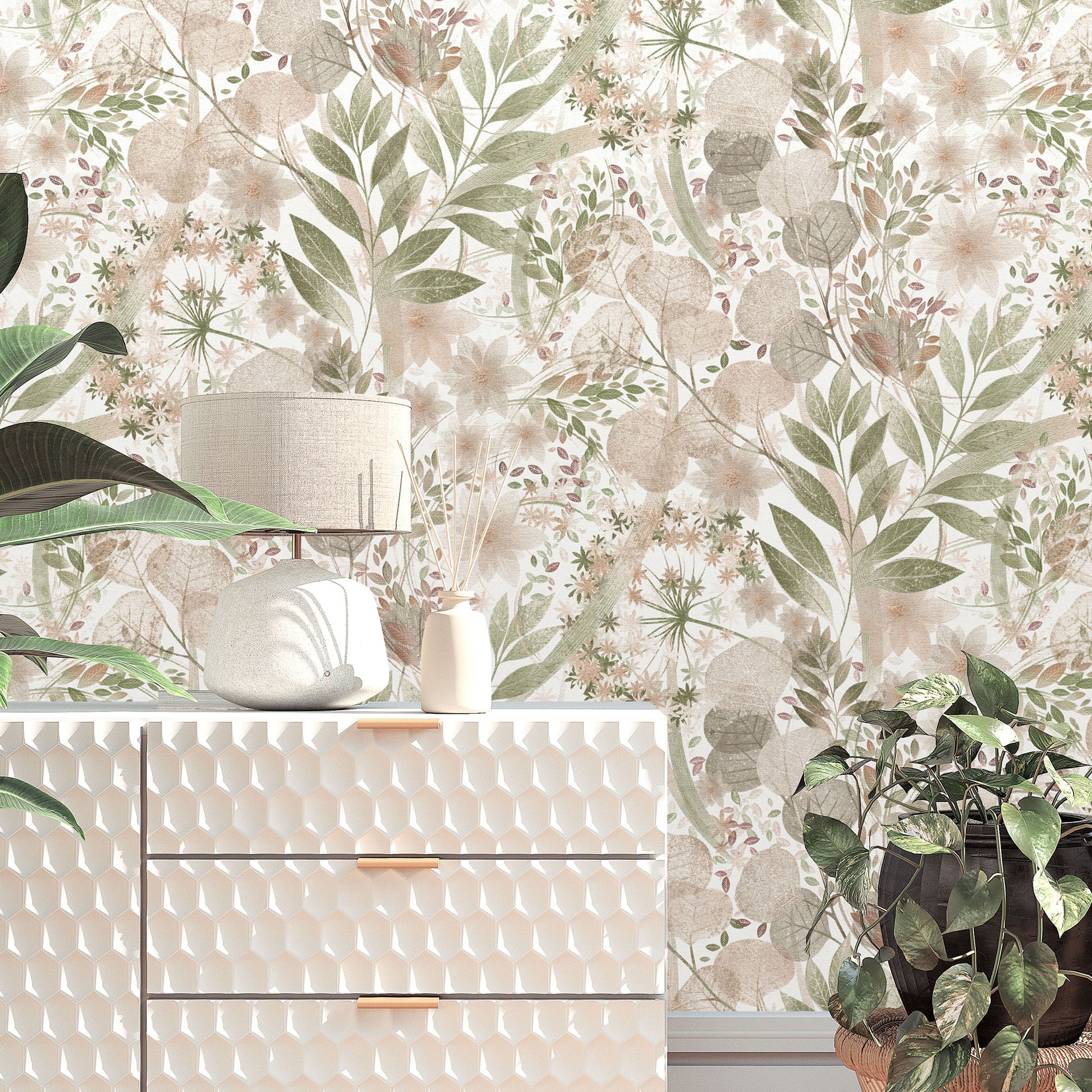 Pink floral wallpaper with green leaves behind a white textured dresser with gold pulls, a lamp, a vase, and plants.