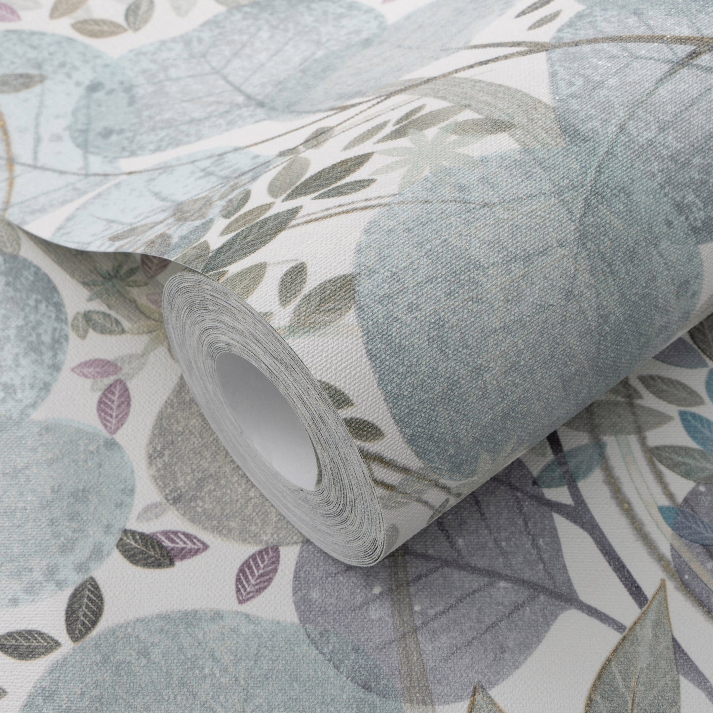 Roll of botanical wallpaper with muted blue and sage leaves on a light background, partially unrolled.