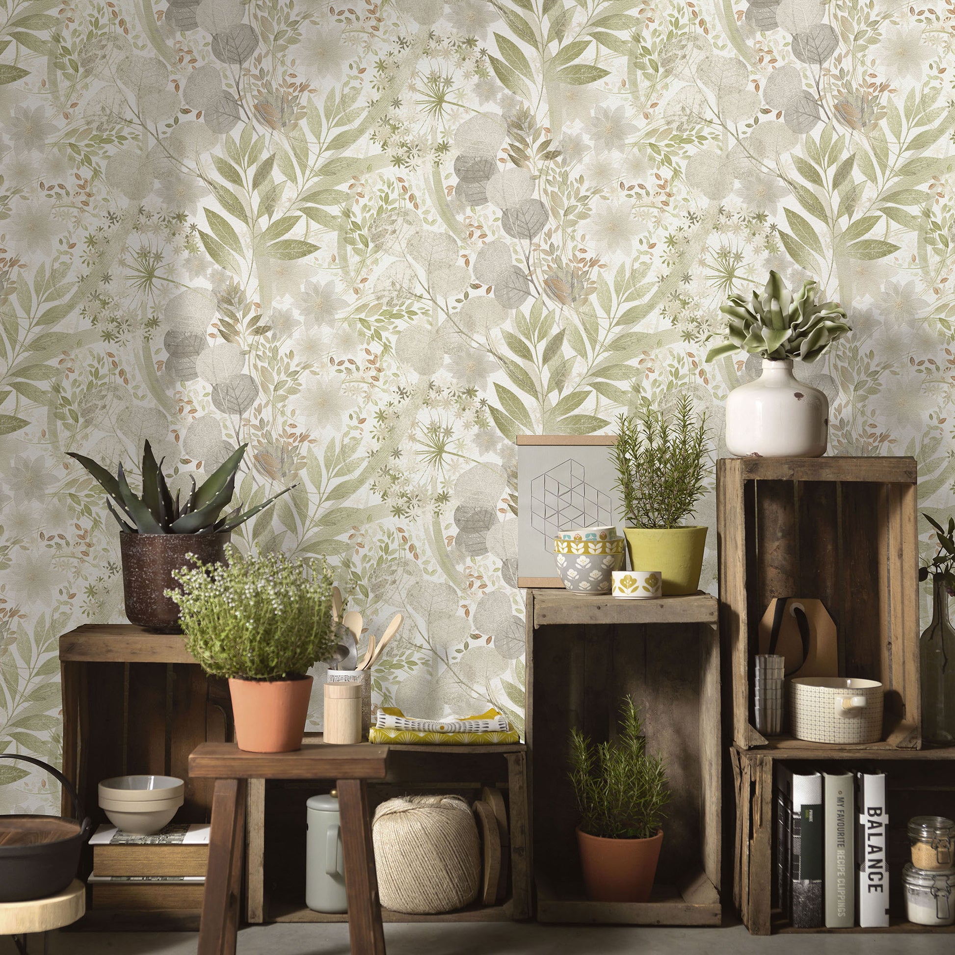 Rustic wooden crate display with potted plants (succulents, herbs) against leafy botanical wallpaper in sage and beige.