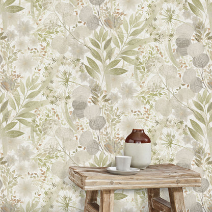Botanical wallpaper in sage, beige and gray tones with leafy motifs; rustic wooden table holding a brown bottle and white cup.