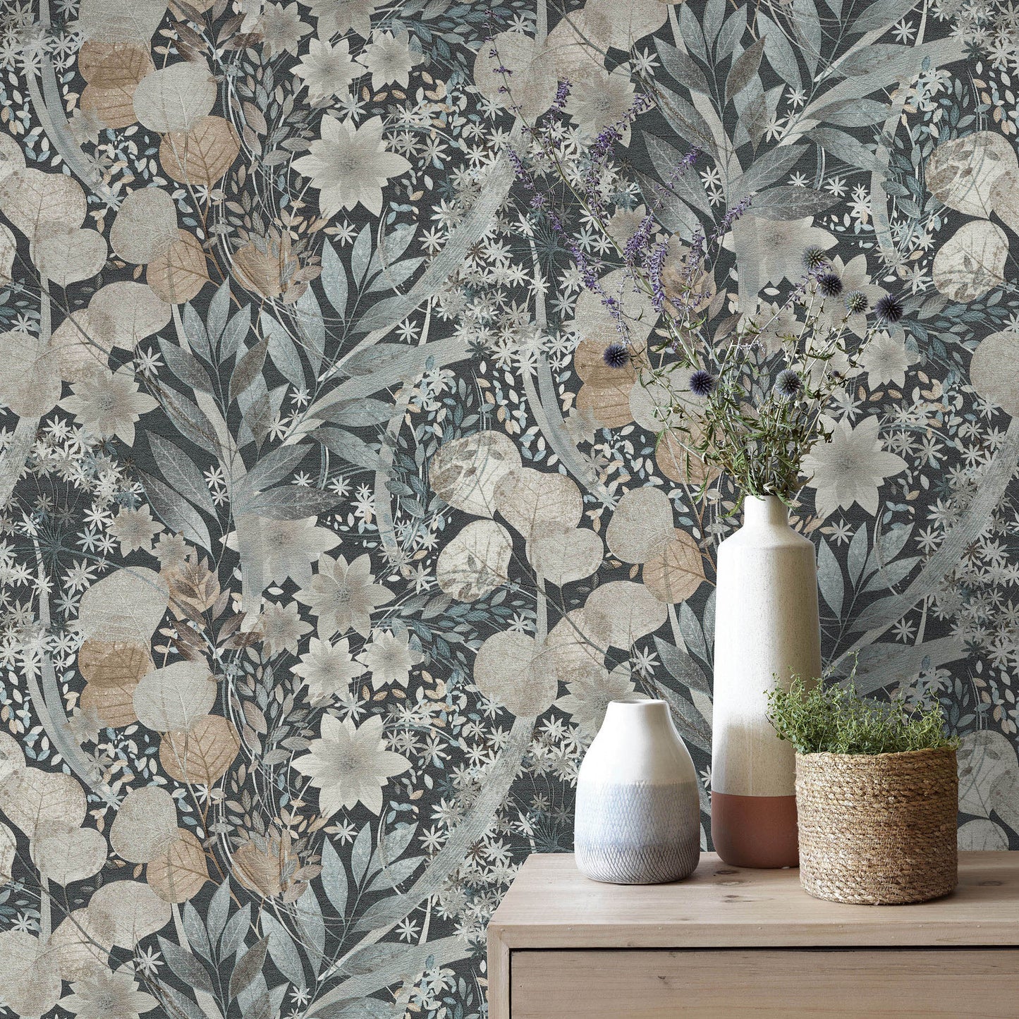 Muted blue-beige floral wallpaper with vines; wooden dresser top displays ceramic vases and a woven plant pot.