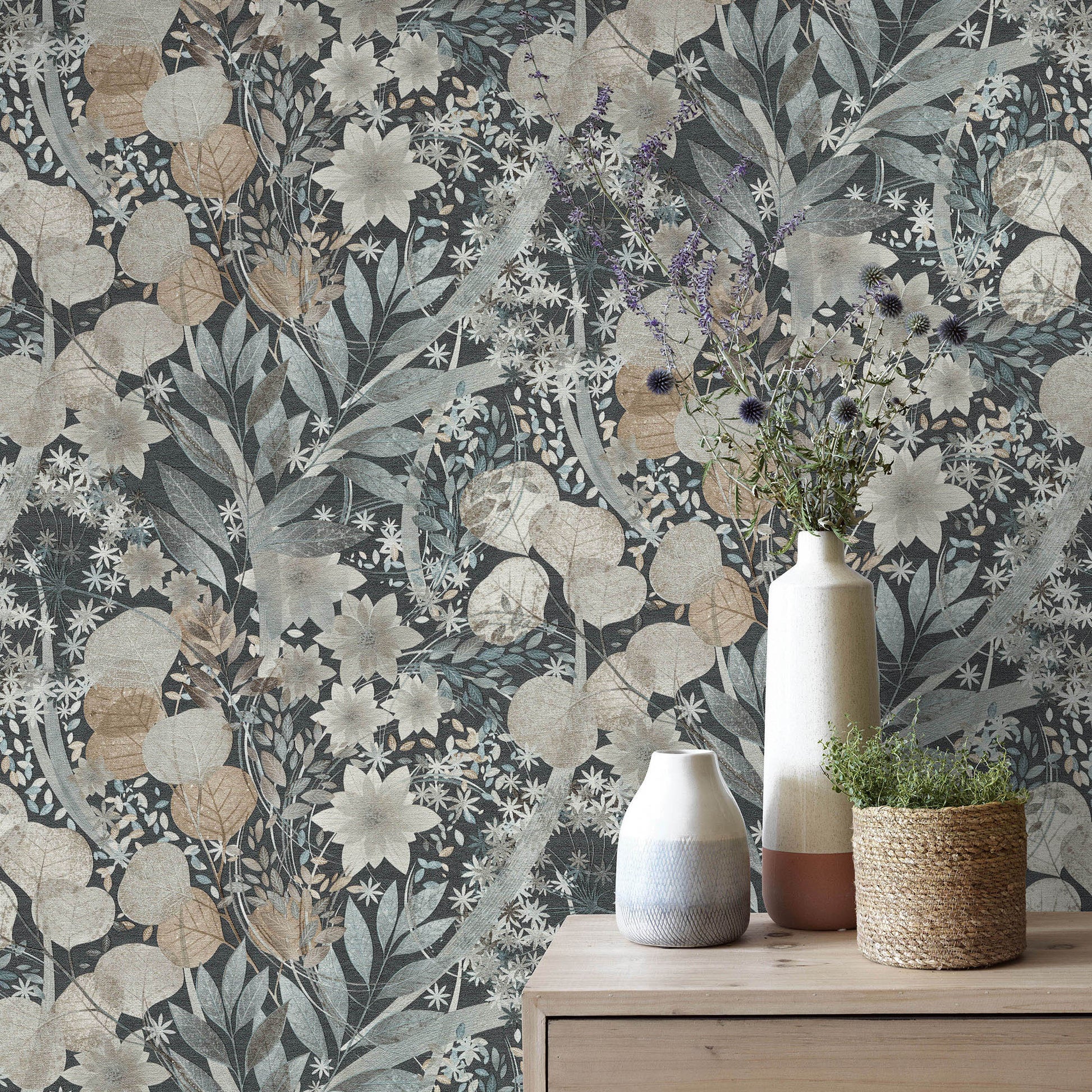 Muted blue-beige floral wallpaper with vines; wooden dresser top displays ceramic vases and a woven plant pot.