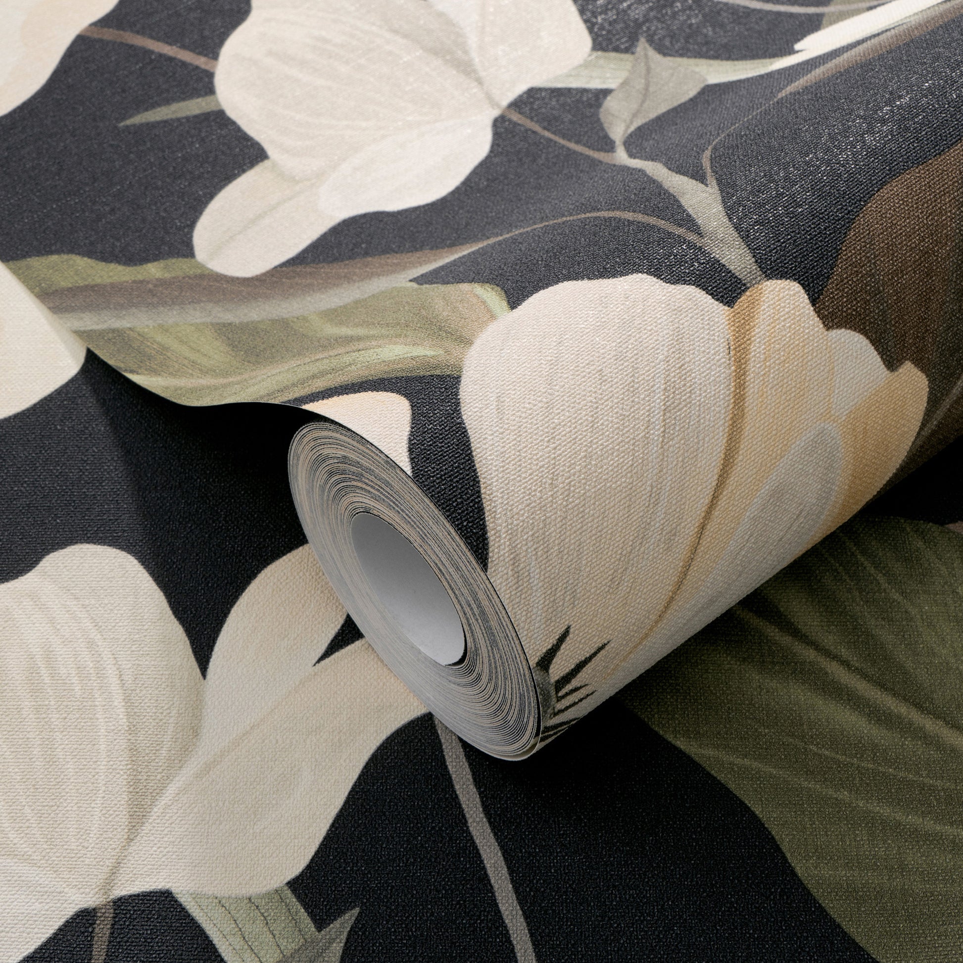 Rolled wallpaper displaying large cream flowers on a dark background; textured fabric-like wallpaper.