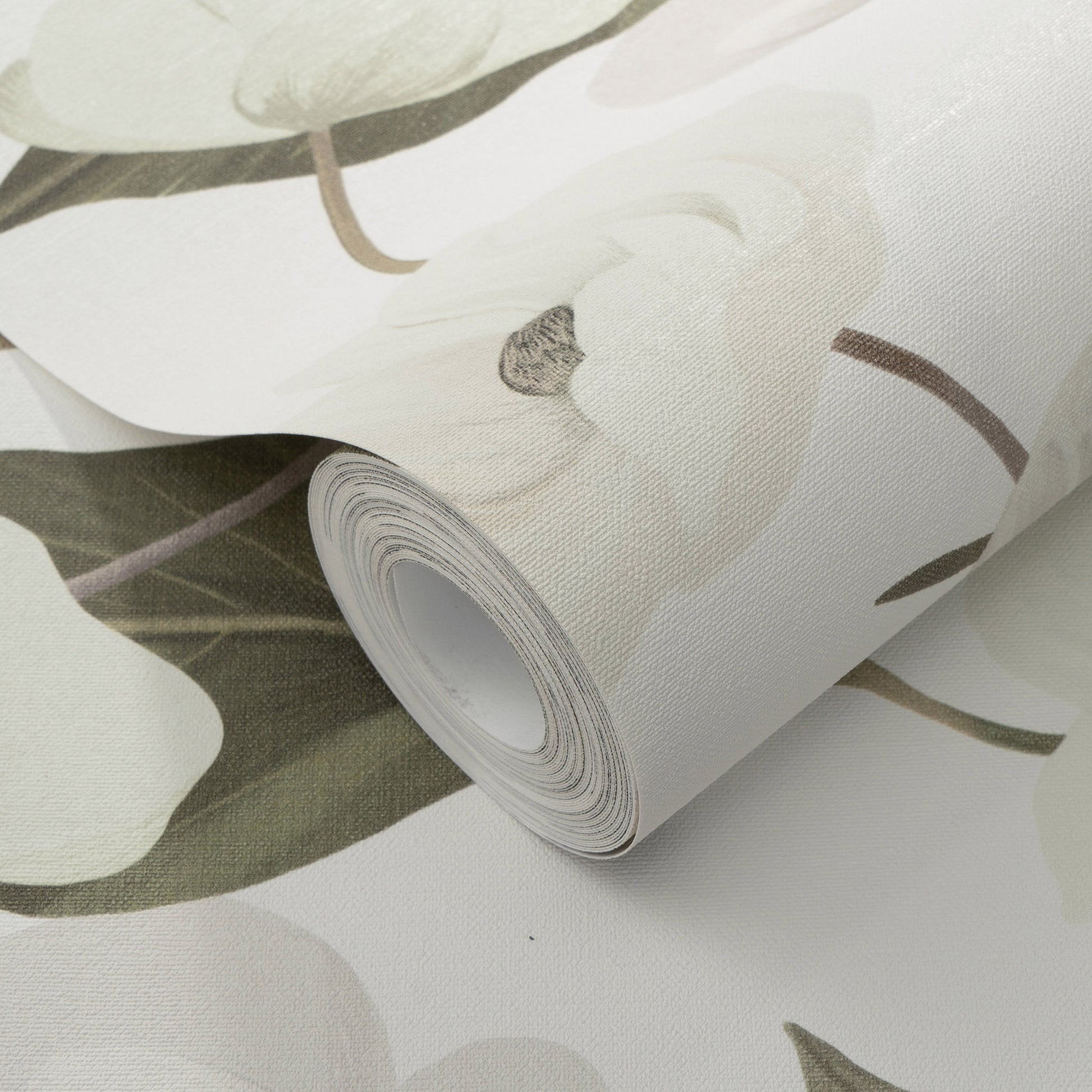 Rolled wallpaper featuring large white orchid blooms on a pale green-gray background, with a textured matte finish.