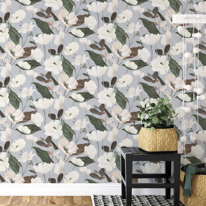 Gray wallpaper with a floral pattern of white blossoms and green leaves.