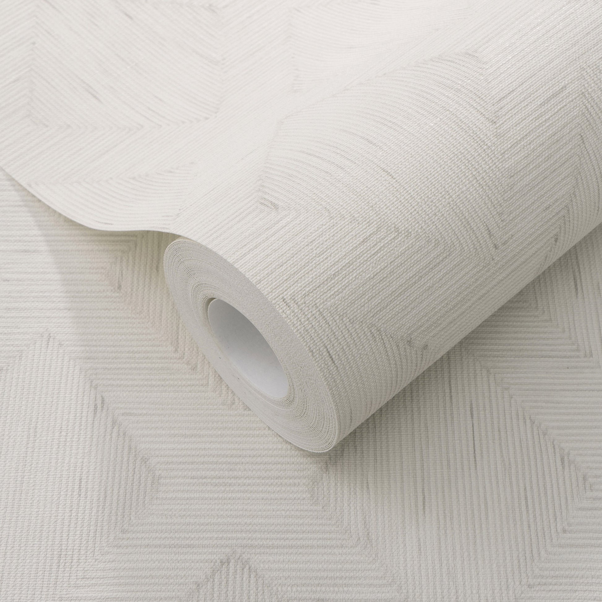 White embossed wallpaper roll with geometric chevron pattern and textured finish.