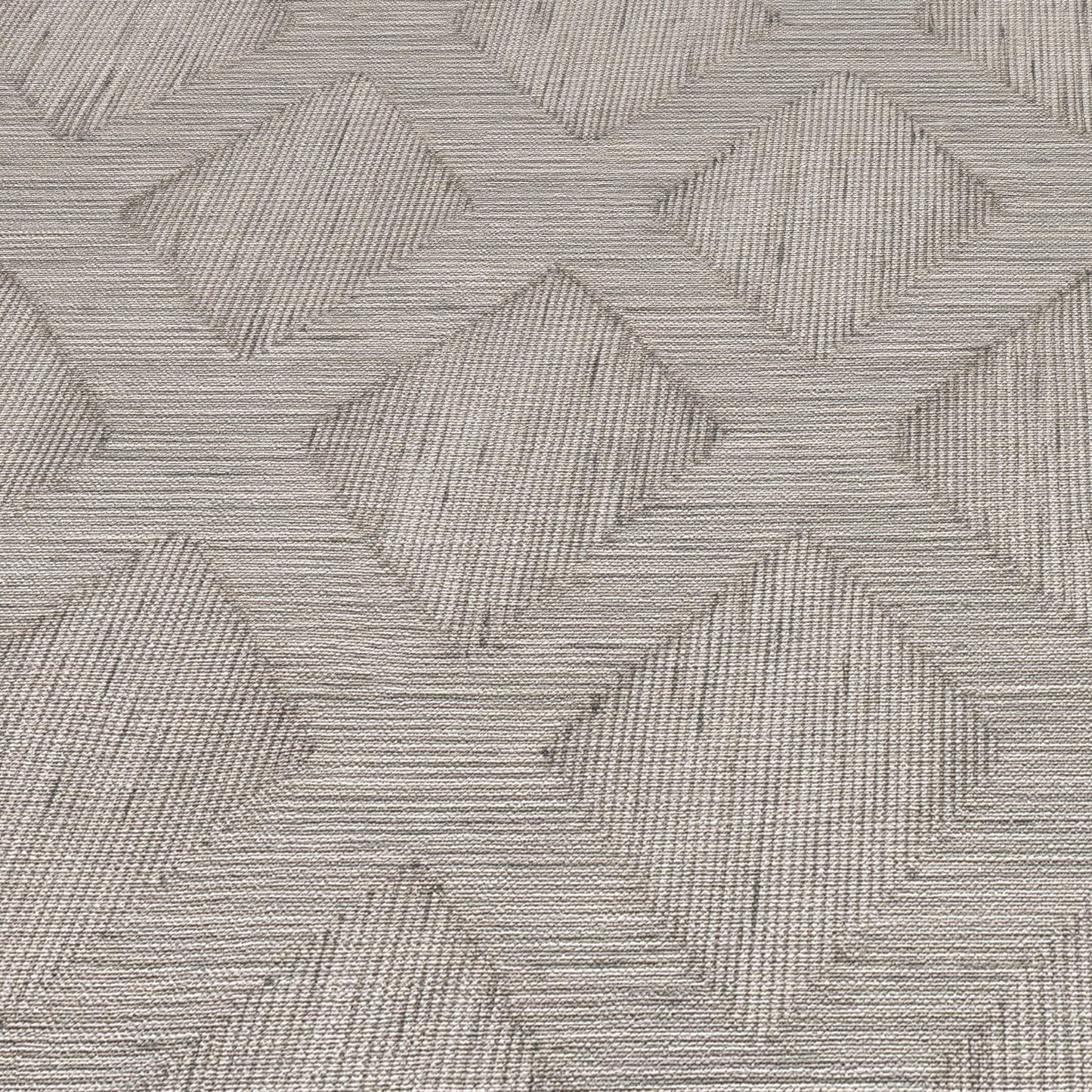Grey woven rug with an interlocking diamond chevron pattern and subtle textured lines.