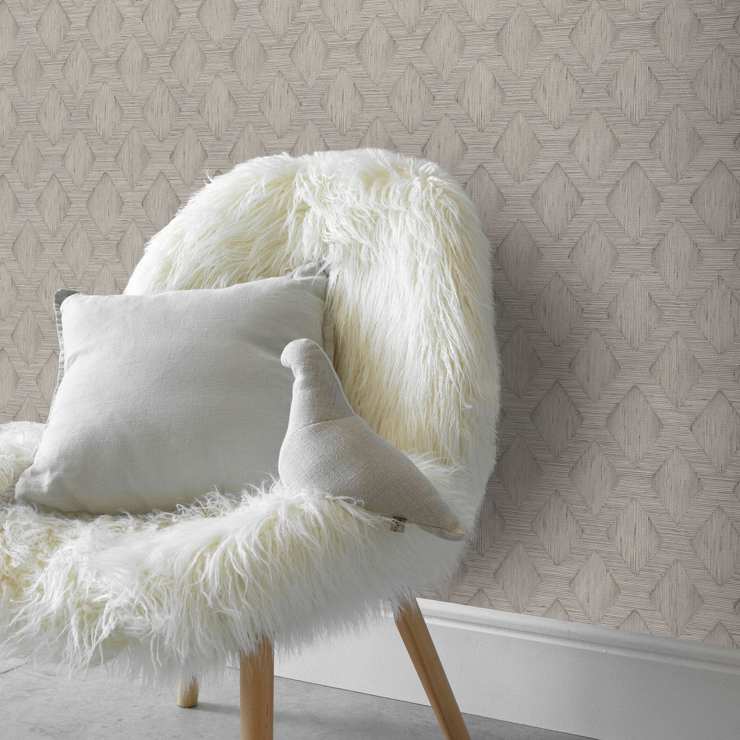 Cream shaggy faux fur chair with light gray cushion and curved plush pillow against geometric wallpaper.