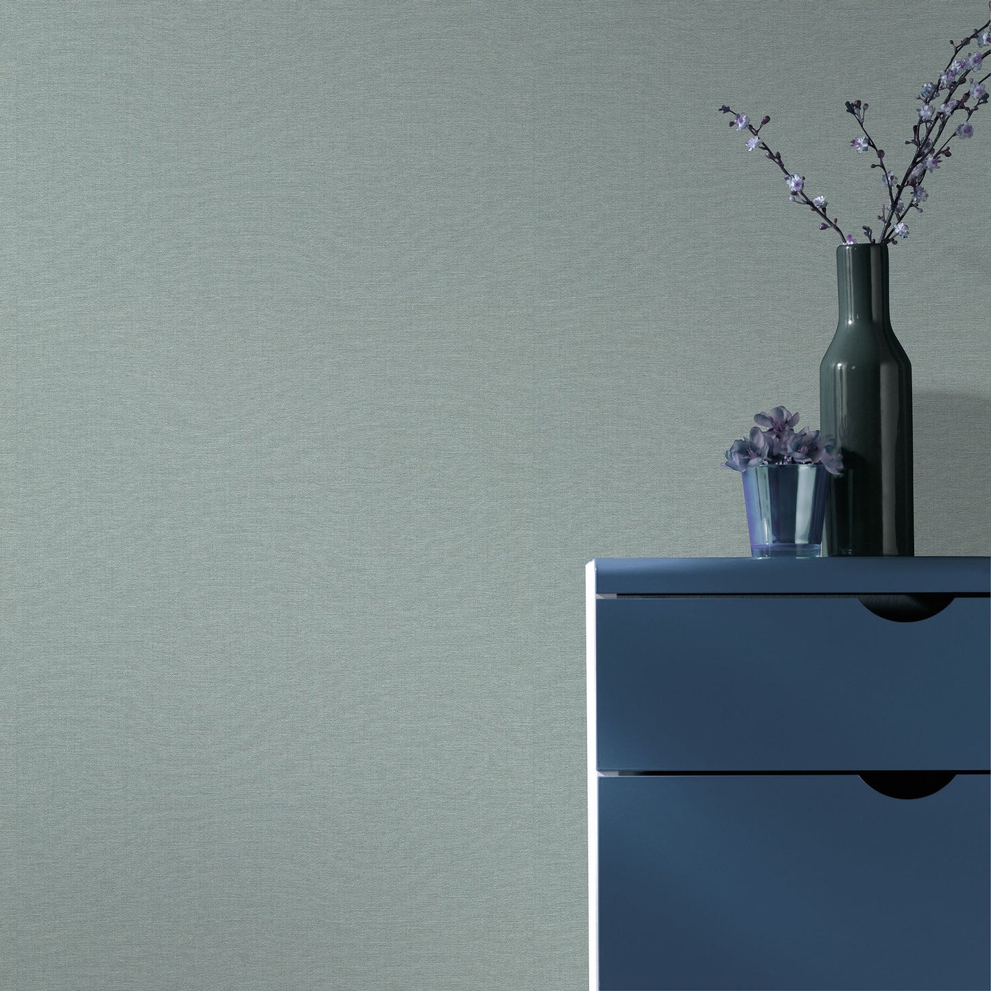Teal wallpaper with a linen-like texture and a traditional pattern.