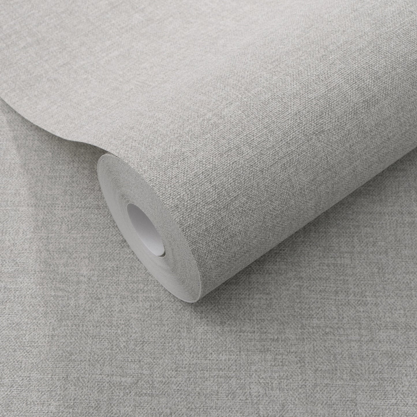 Roll of light gray textured wallpaper with a subtle linen-style weave on a cardboard core.