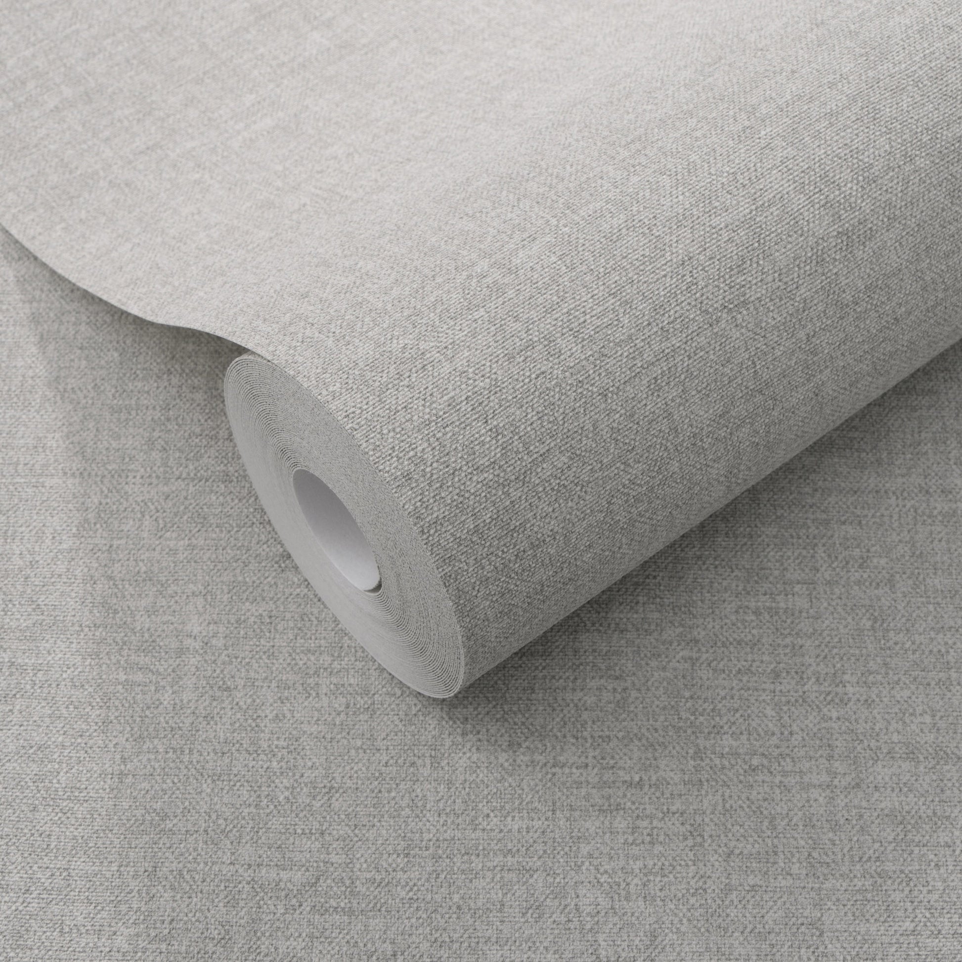 Roll of light gray textured wallpaper with a subtle linen-style weave on a cardboard core.