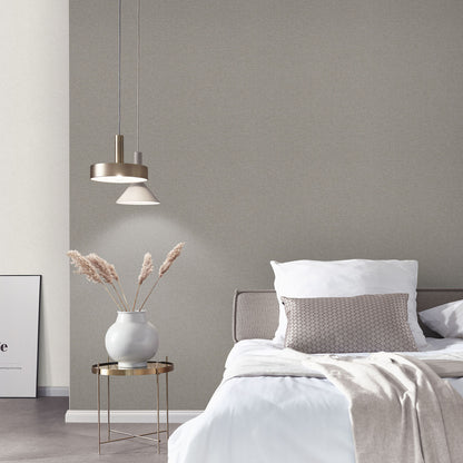 Neutral bedroom with white bedding, beige pillow, round side table, white vase with dried grasses, copper pendant lights.